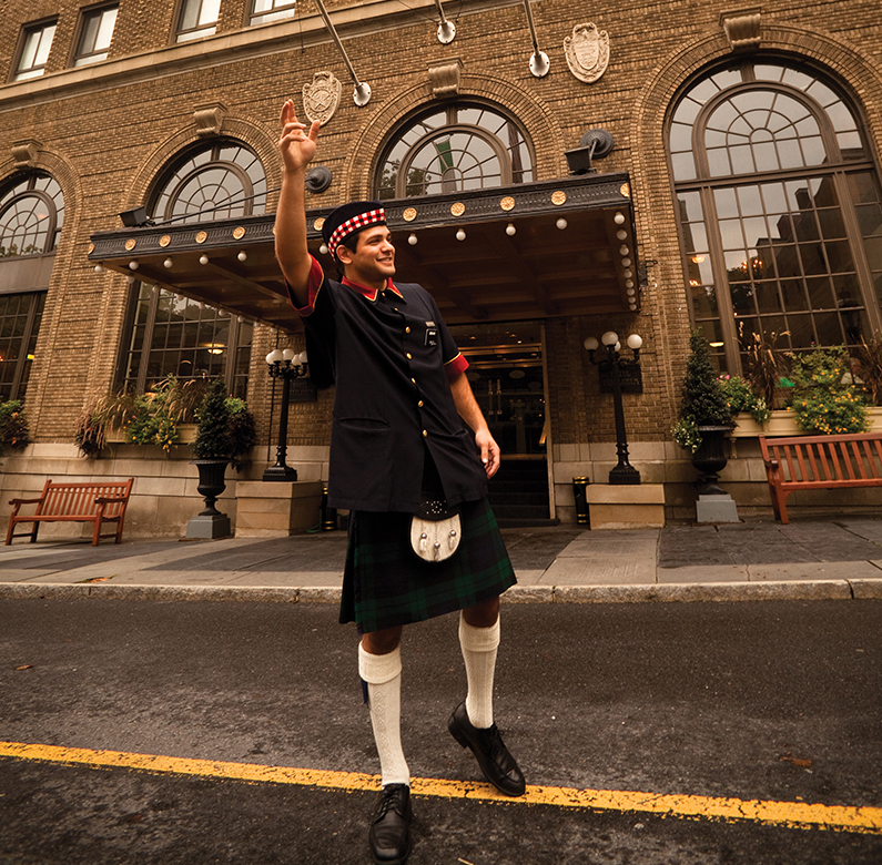 a man in kilt holding up a trophy