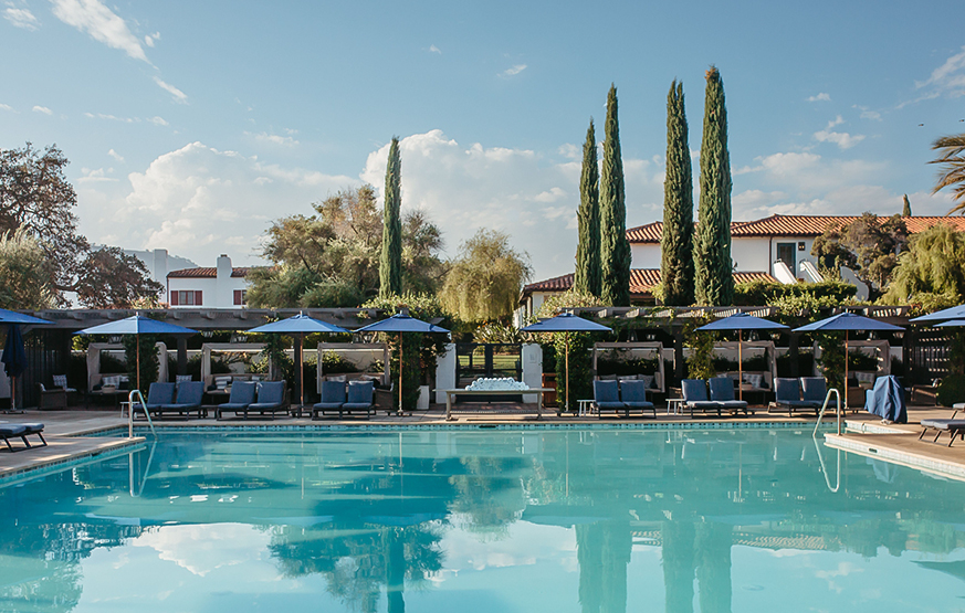 a pool with chairs and umbrellas by it
