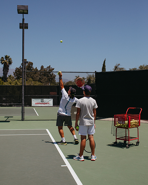 two men playing tennis on a court